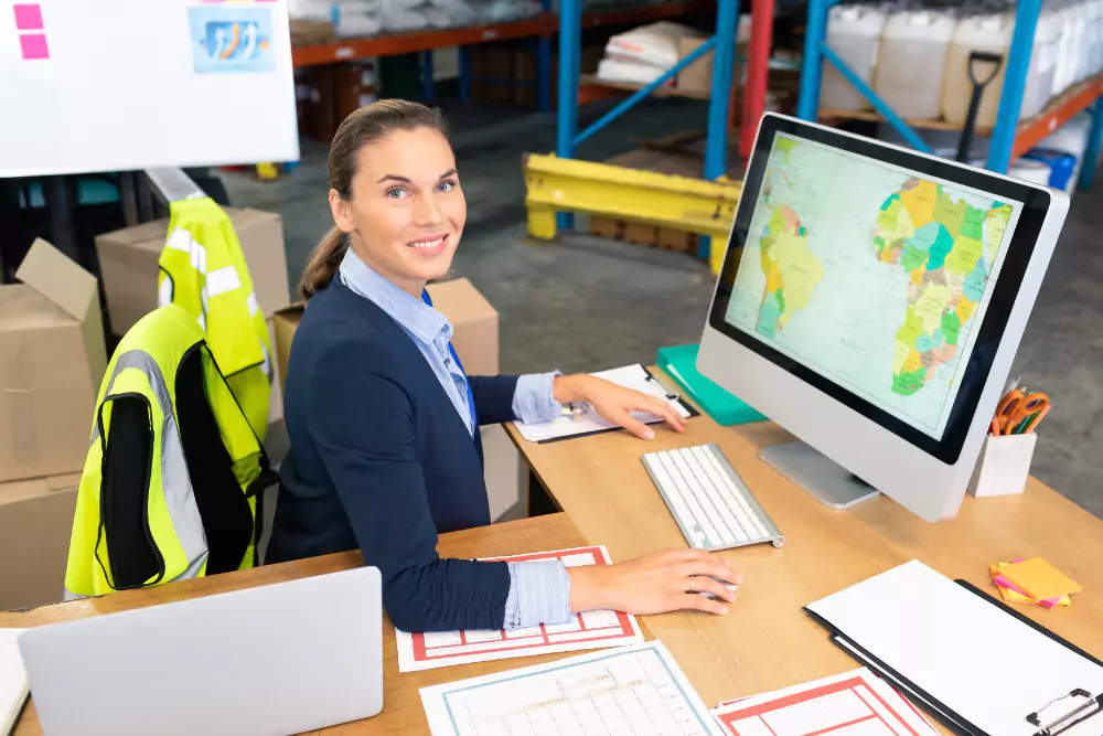 A woman in a warehouse is using a tablet computer. She is likely checking inventory or managing orders.