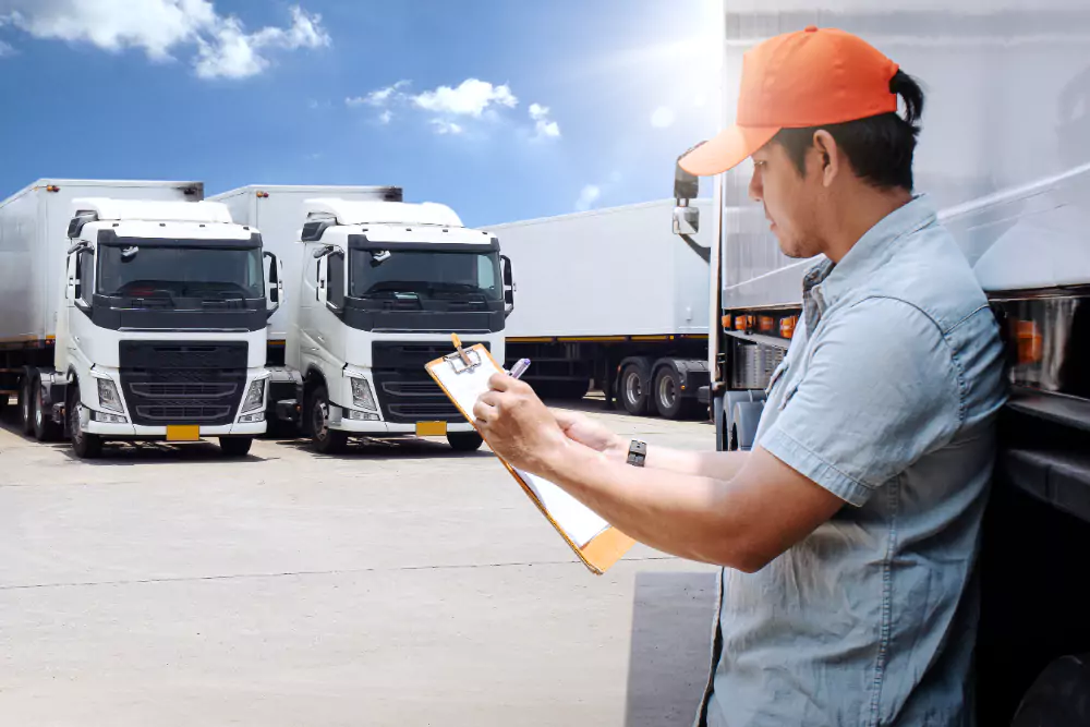 Man reviewing Road Freight Transport Management with vehicles in the background, overseeing efficient transport operations.